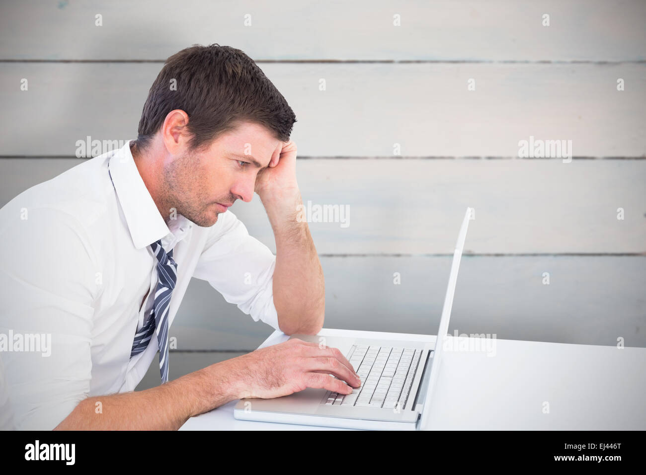 Composite image of businessman working on laptop Banque D'Images