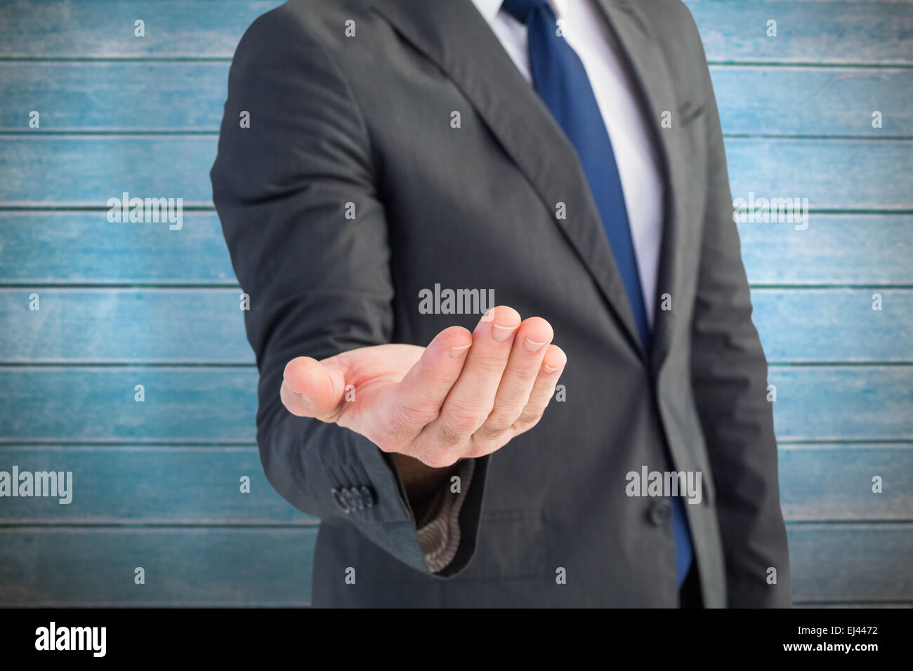 Composite image of businessman holding sa main Banque D'Images