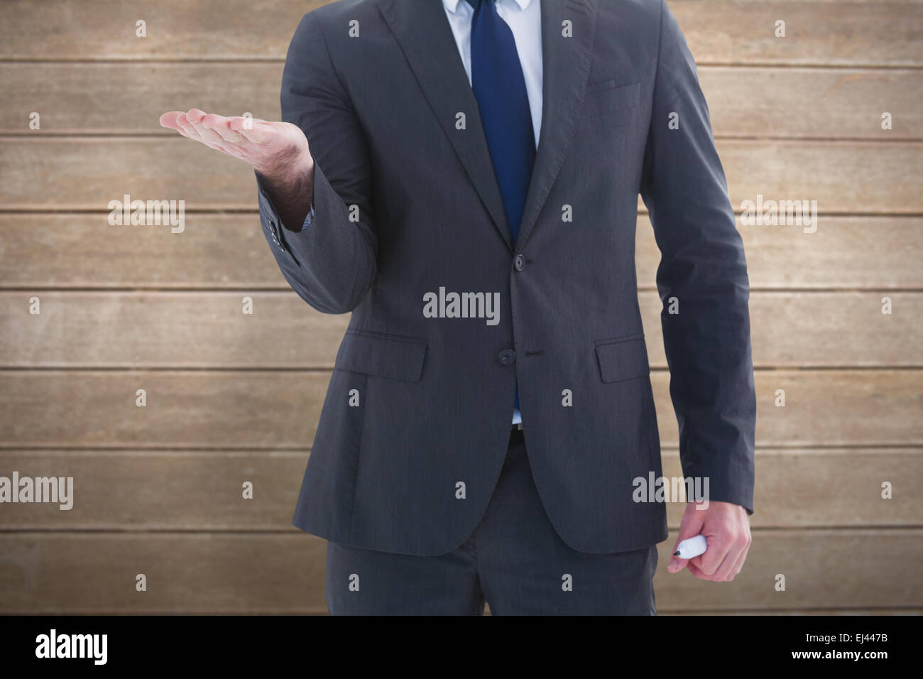 Composite image of businessman holding hand out dans la présentation Banque D'Images