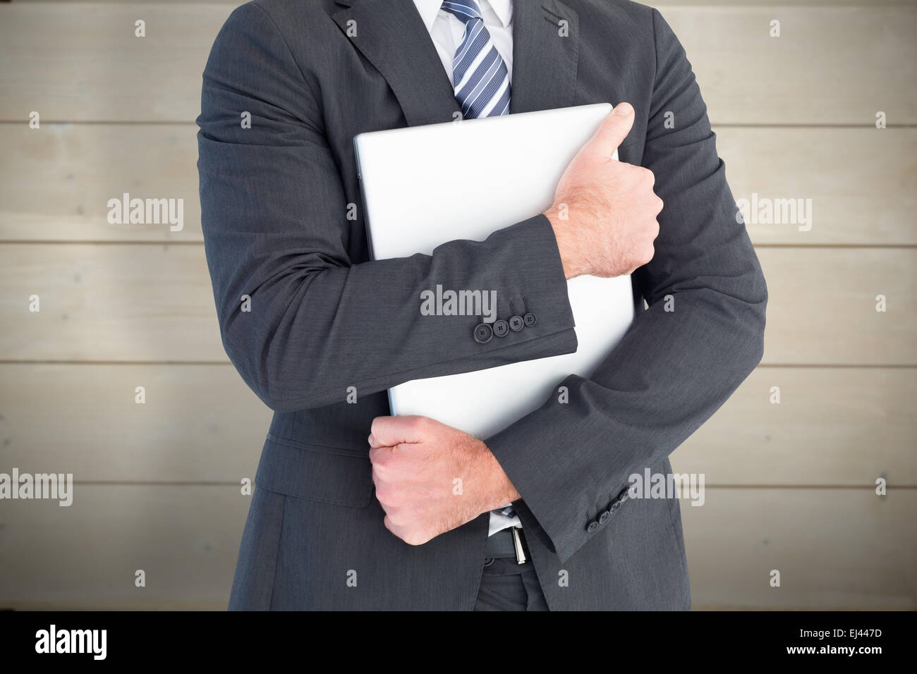 Composite image of businessman holding étroitement sur son ordinateur portable. Banque D'Images