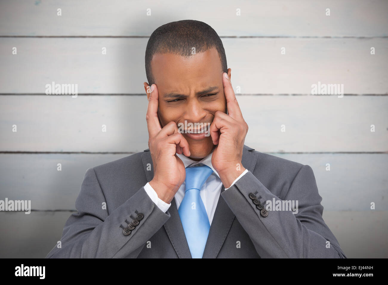 Composite image of businessman mettant ses doigts sur ses tempes Banque D'Images