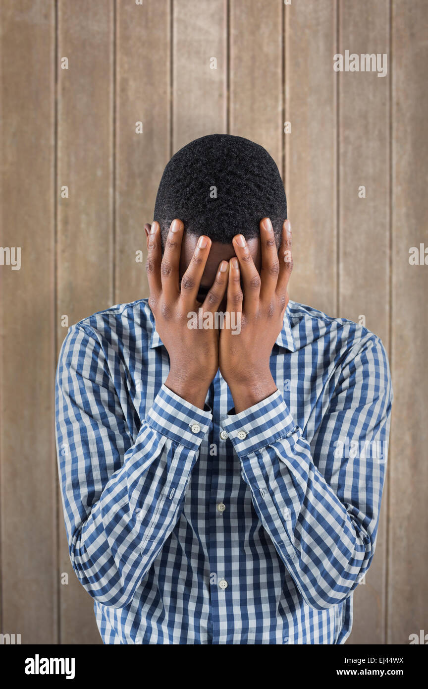 Composite image of young businessman with head in hands Banque D'Images