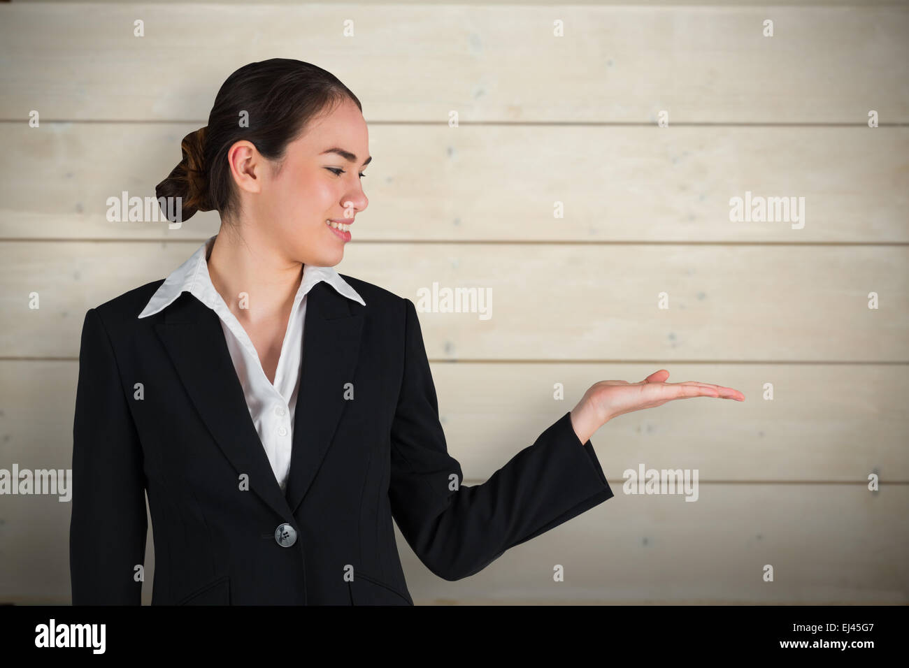 Composite image of businesswoman with hand out Banque D'Images