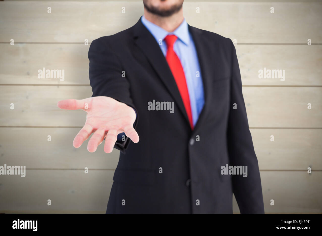Composite image of businessman holding hand out dans la présentation Banque D'Images
