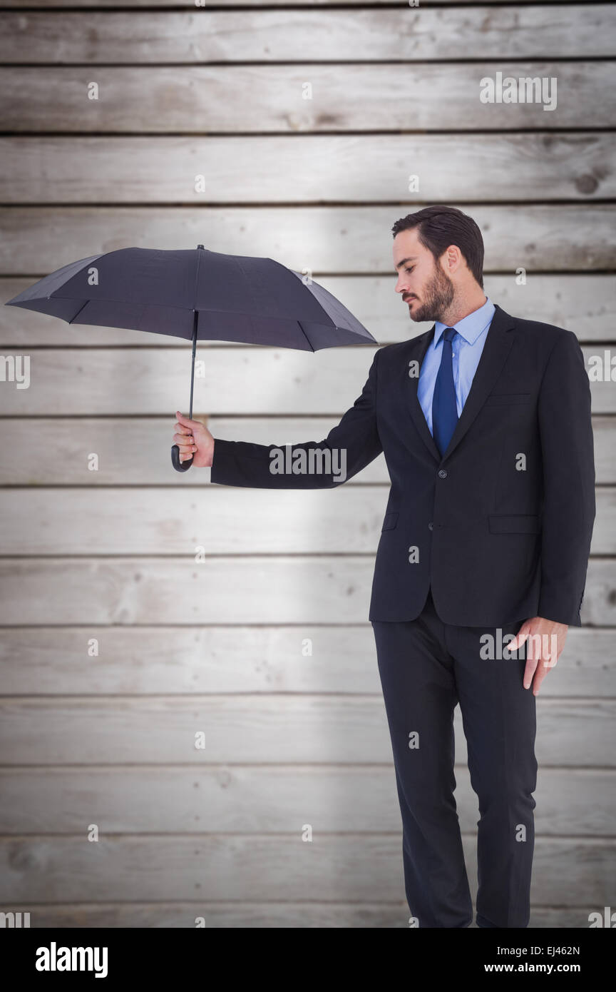 Composite image of businesswoman in suit holding umbrella Banque D'Images