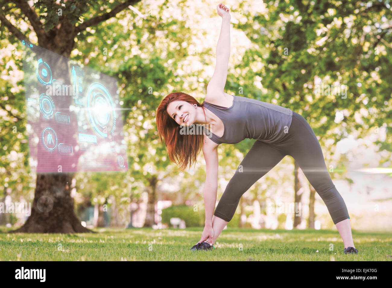 Image composite de jolie rousse athlétique qui s'étend dans le parc Banque D'Images