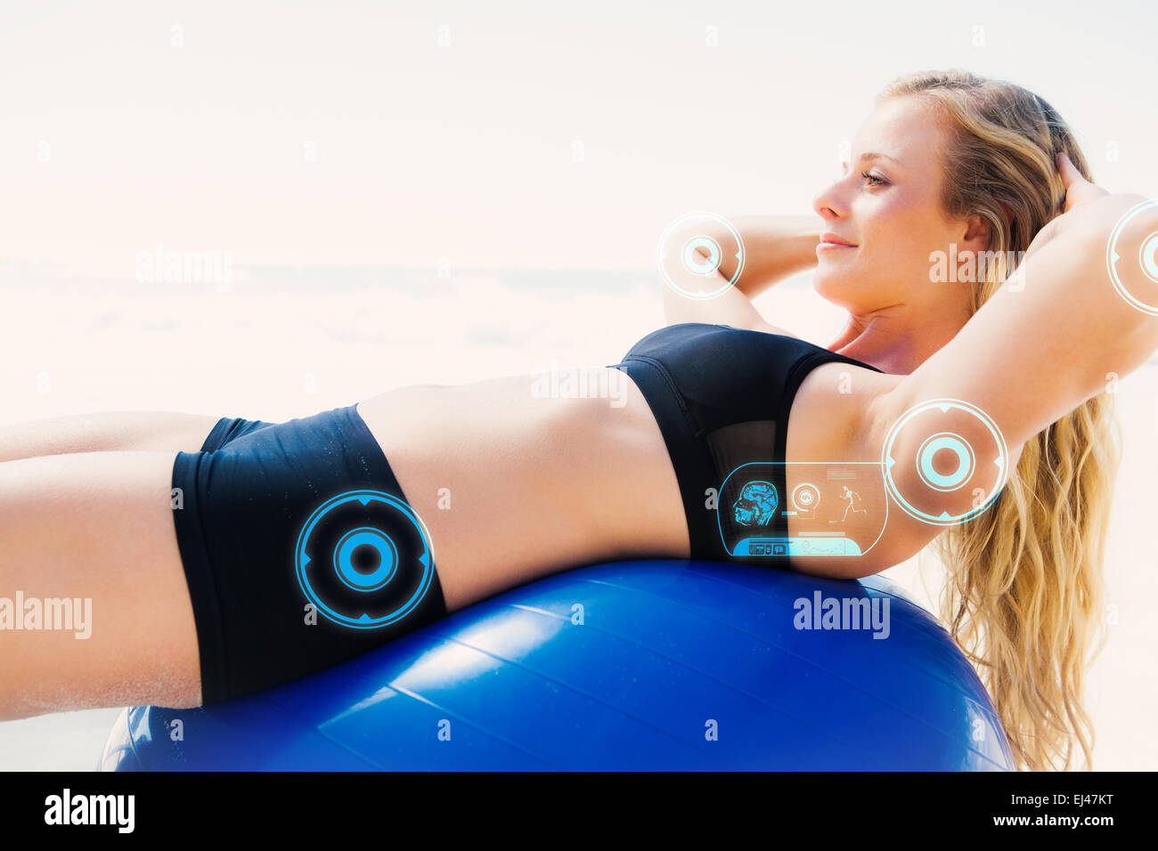 Image composite de la fit asseoir sur ups blonde faisant boule d'exercice à la plage Banque D'Images