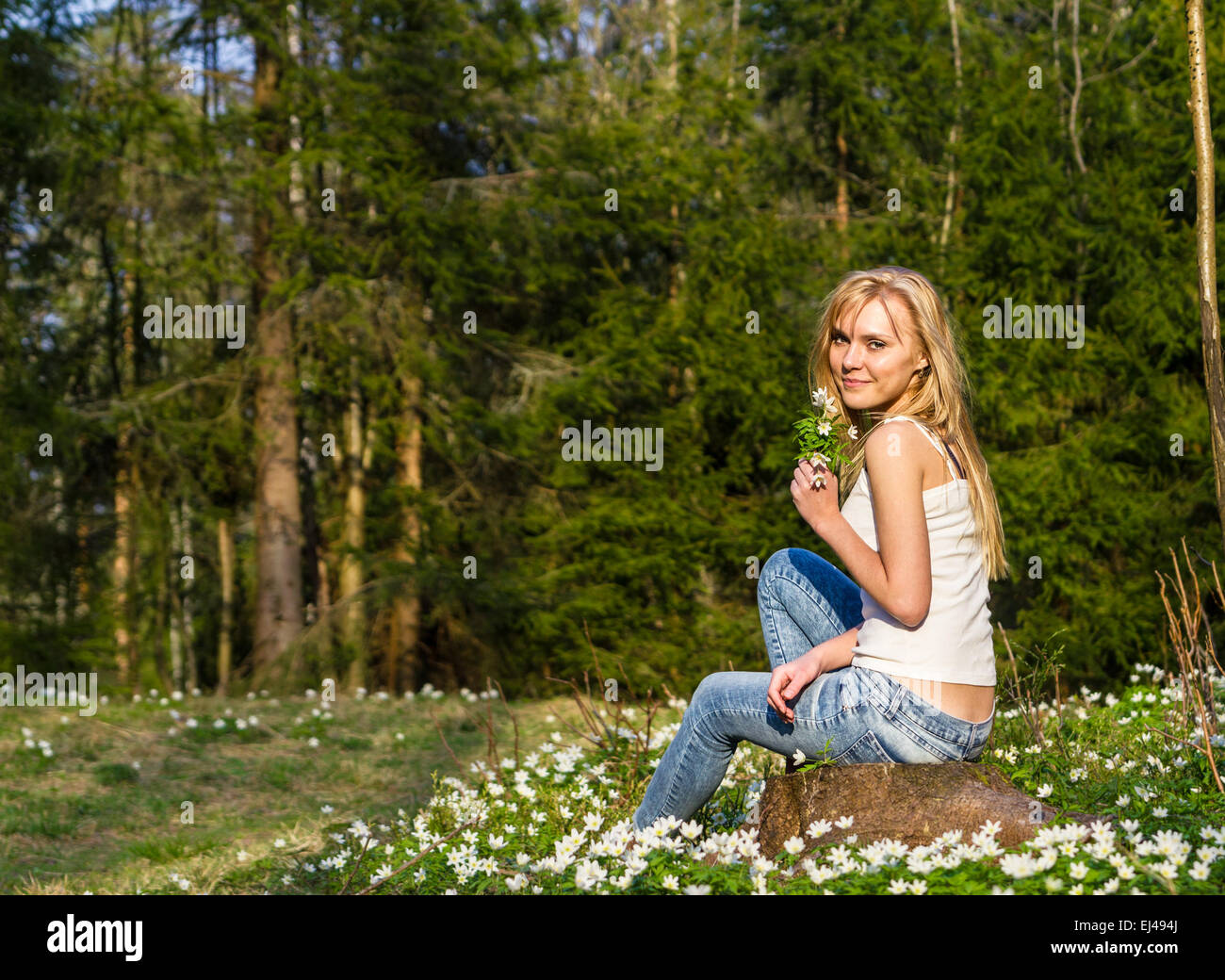 Très jolie jeune femme sur une prairie avec des fleurs Banque D'Images