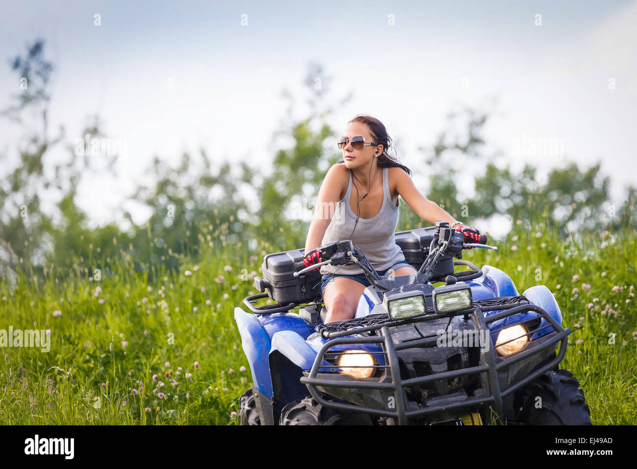 Équitation femme quadrocycle élégant extrême dans summer fields Banque D'Images