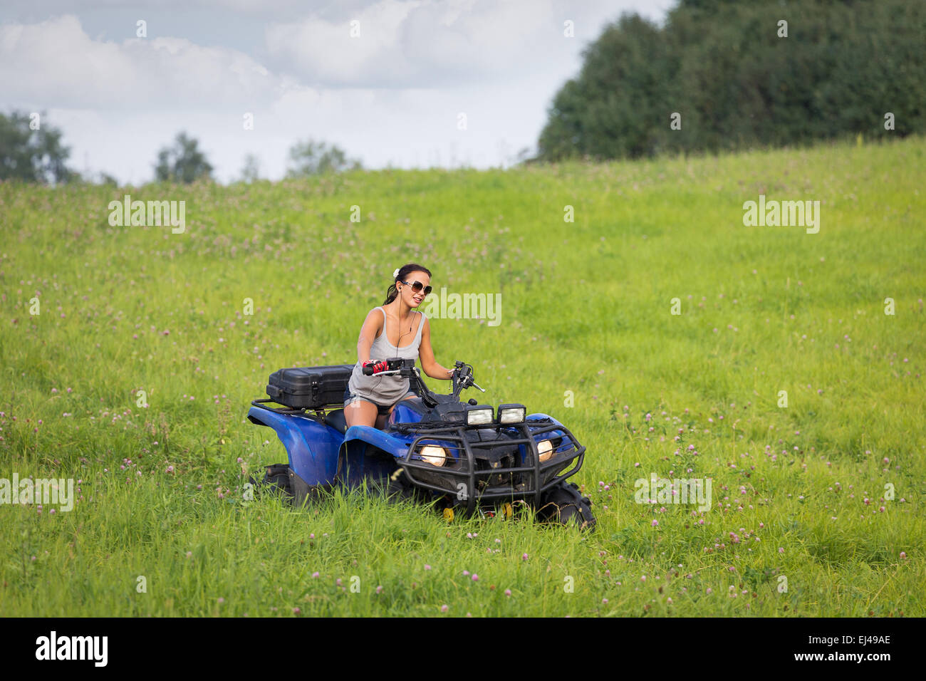 Équitation femme quadrocycle élégant extrême dans summer fields Banque D'Images