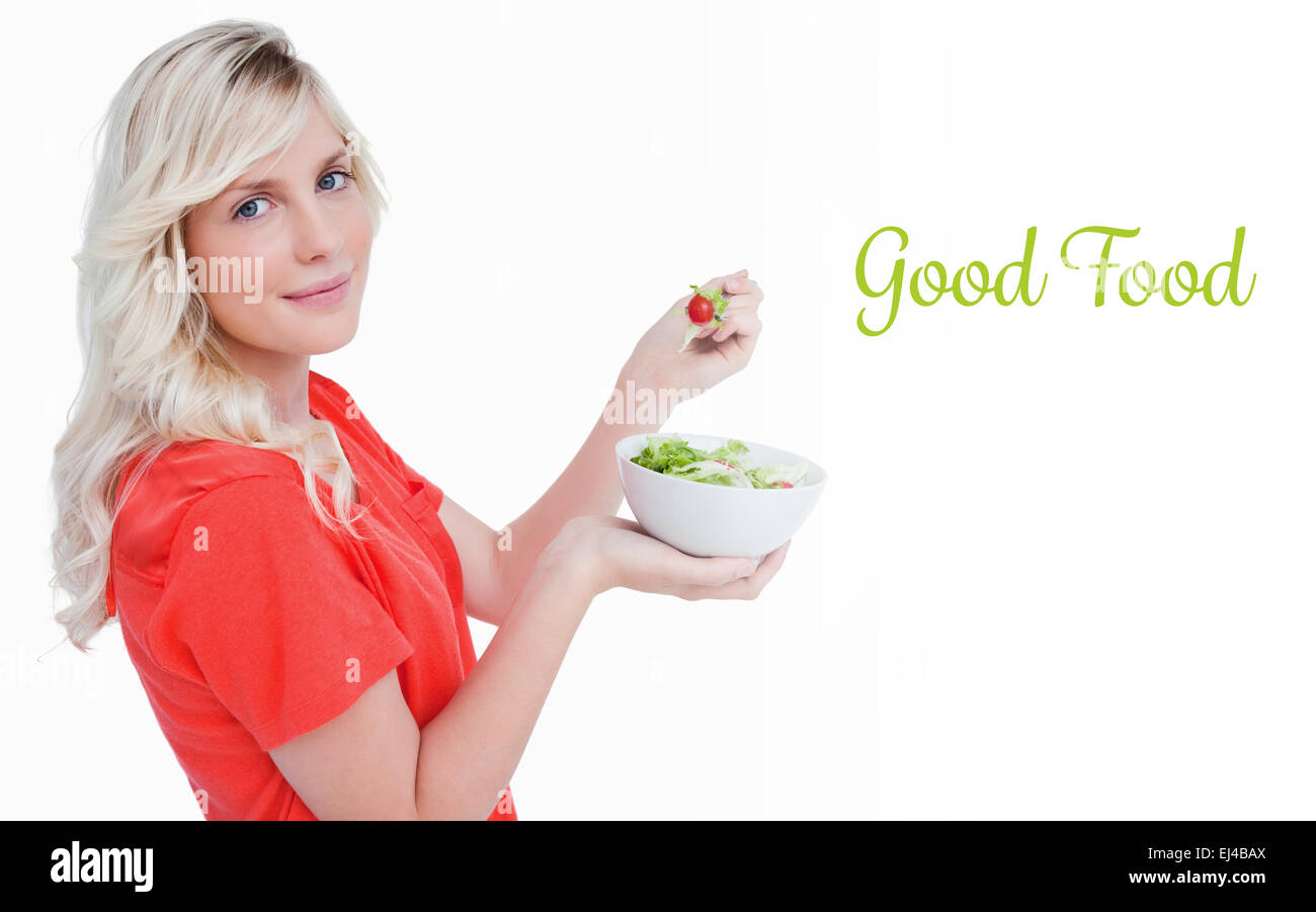 Bonne nourriture contre vue latérale d'une jeune femme blonde de manger une salade de légumes Banque D'Images
