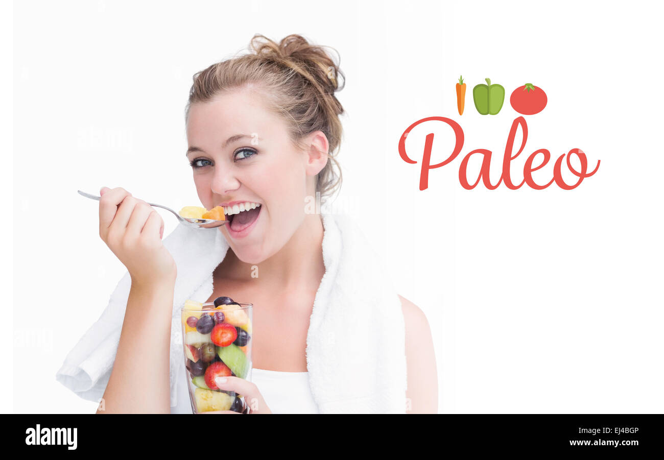 Paleo against woman eating fruit and smiling Banque D'Images