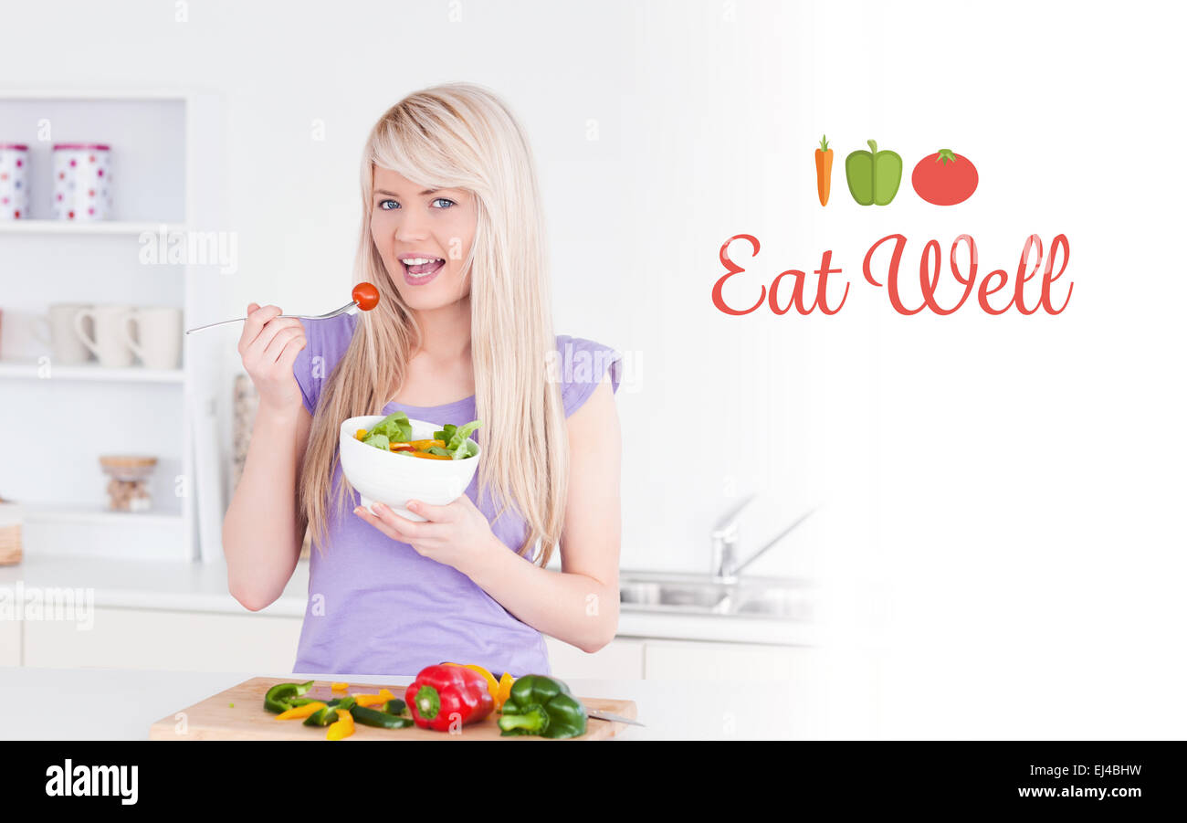 Bien manger contre blonde female manger sa salade Banque D'Images