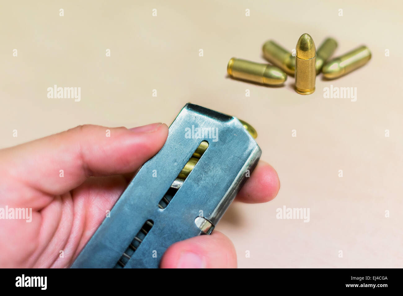 Magazine de munitions dans une main avec des balles de 9 mm Banque D'Images
