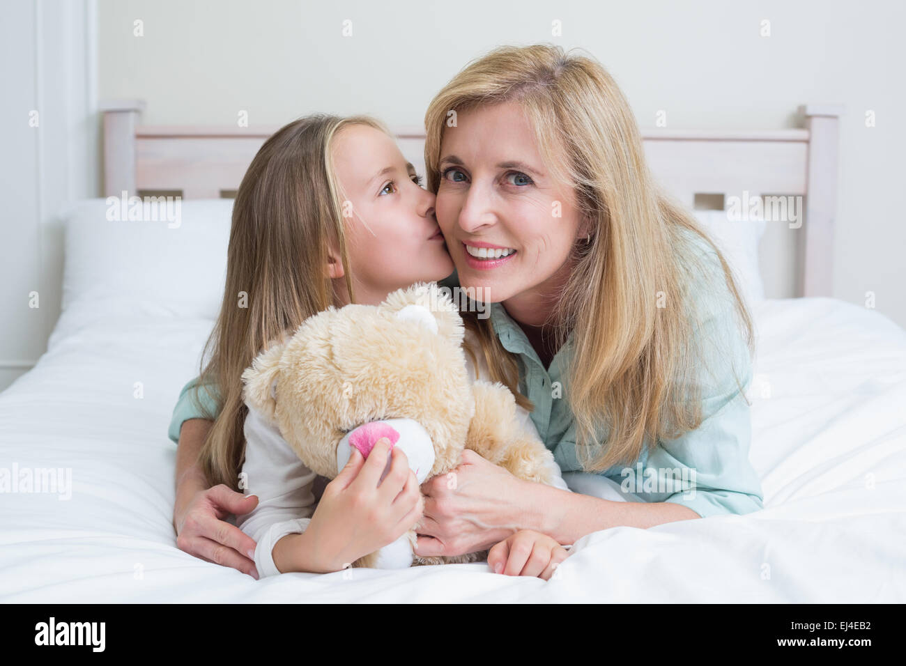 Cute girl kissing her smiling mother Banque D'Images