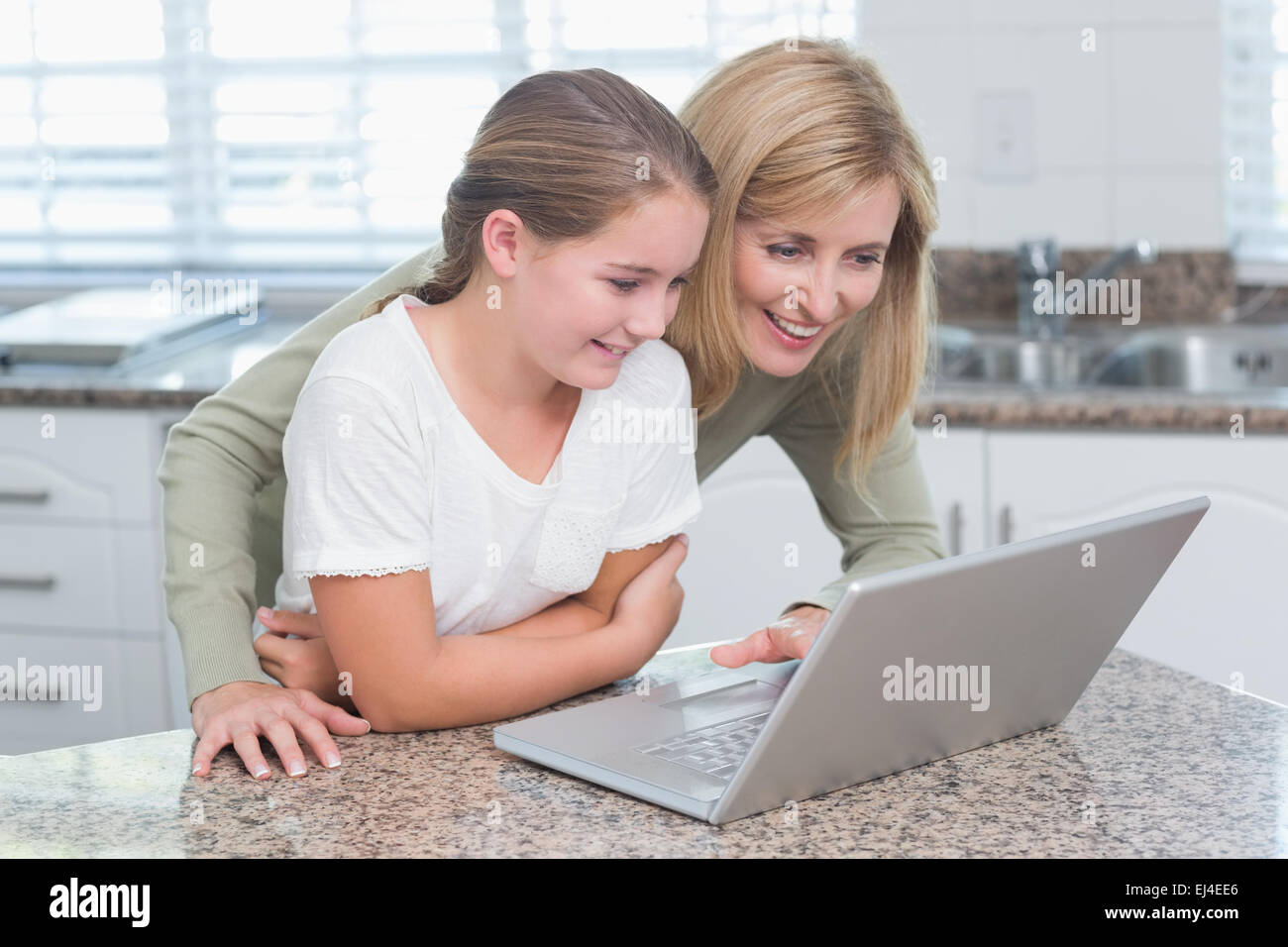 Happy mother and daughter using laptop together Banque D'Images