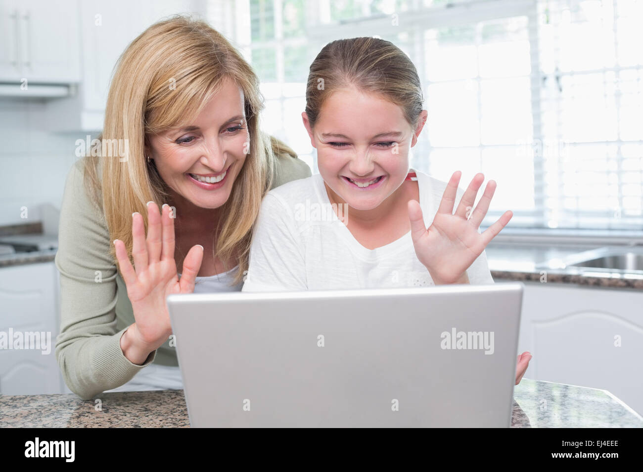 Mère et fille de parler avec quelqu'un avec l'ordinateur portable Banque D'Images