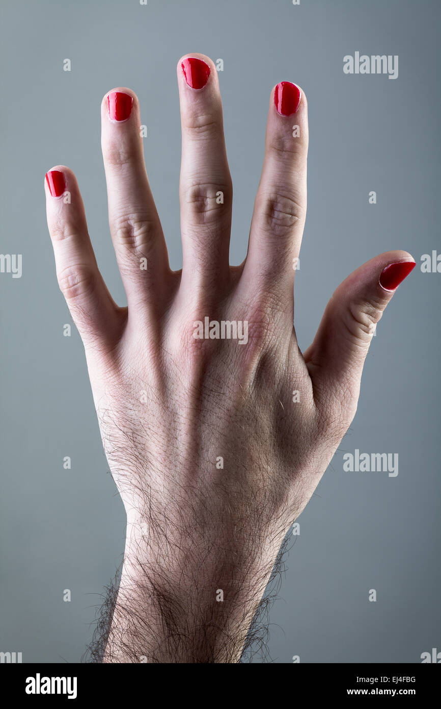 La main de l'homme avec du vernis à ongles rouge sur fond gris Banque D'Images