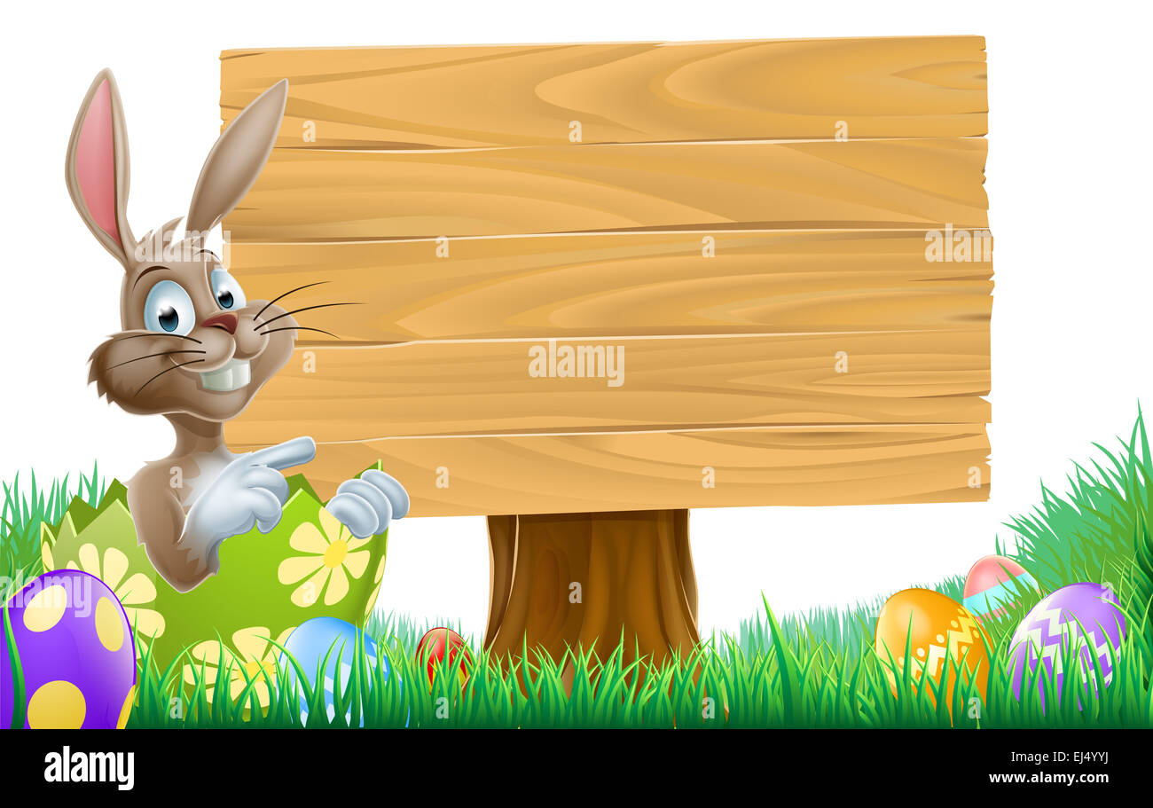 Cartoon Lapin de Pâques à l'intérieur d'un œuf de Pâques pointant sur un panneau en bois Banque D'Images