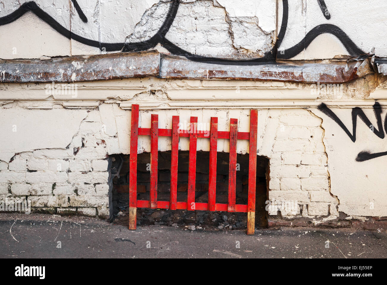 Vieille clôture en bois rouge sur de vieux grungy wall background Banque D'Images