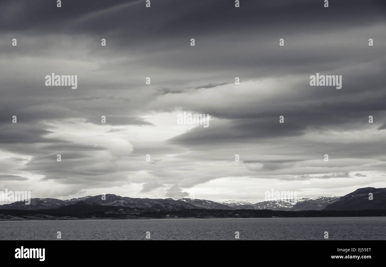 Paysage côtier norvégien monochrome avec vue mer spectaculaire et ciel orageux Banque D'Images