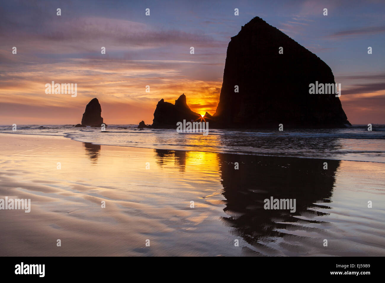 Coucher de soleil sur Haystack Rock et d'autres piles de mer à Cannon Beach, Oregon, USA. Banque D'Images
