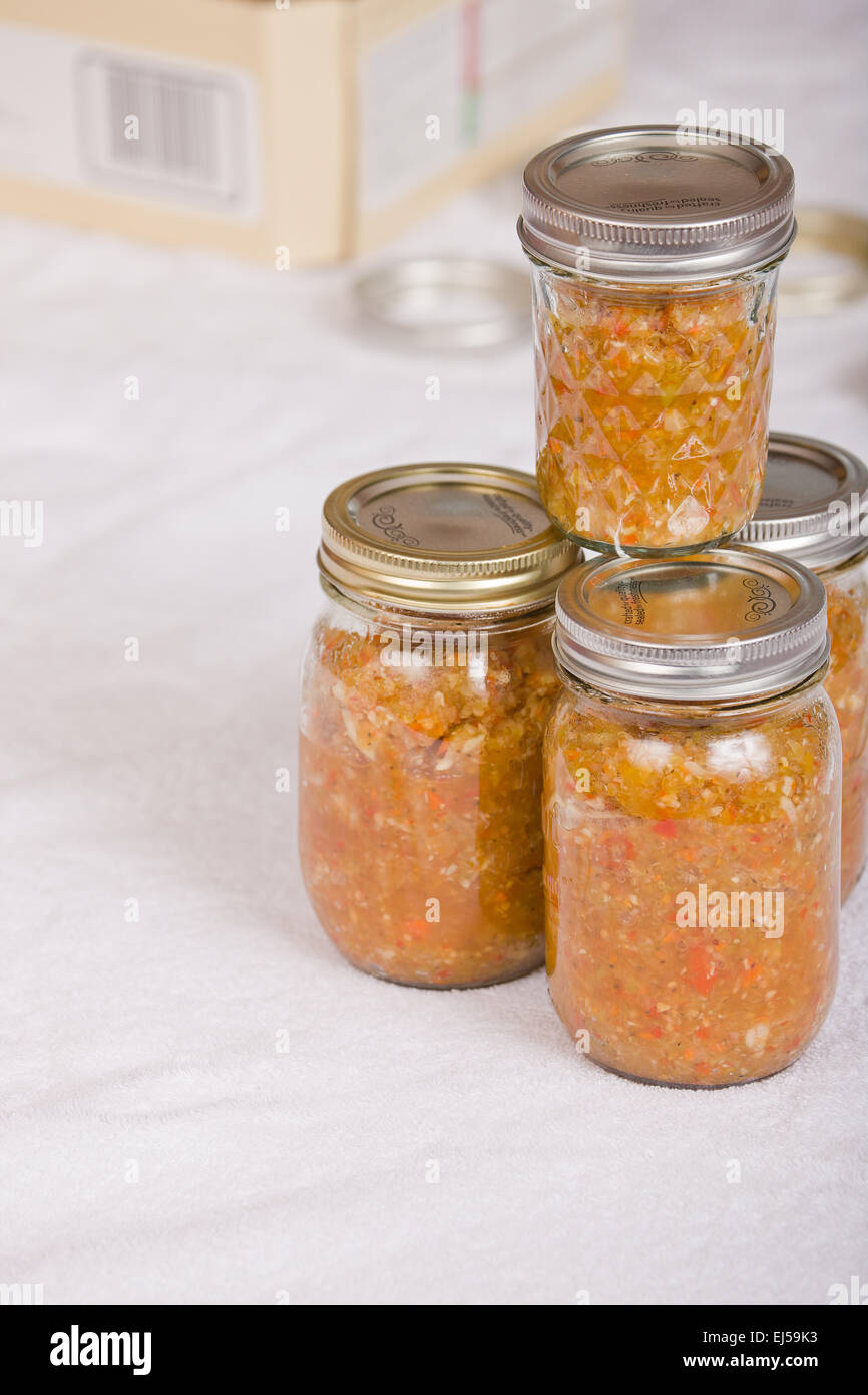 Pots de relish mis en conserve à la maison sur une serviette blanche avec un pot Fort Canning en arrière-plan, avant de par-L'ébullition Banque D'Images