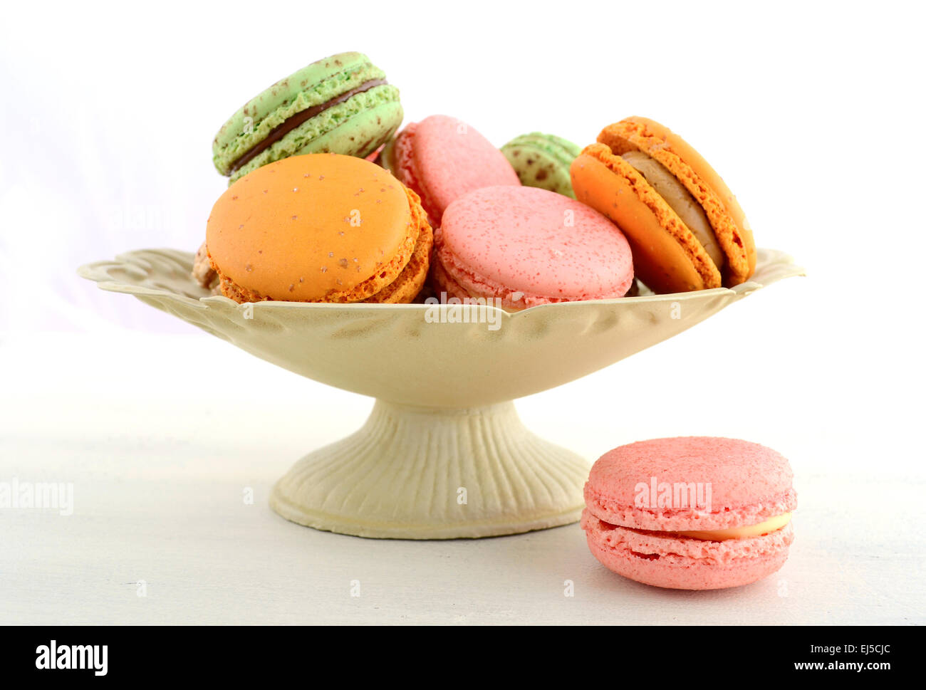 La fraise, de couleur caramel et chocolat macarons à la menthe sur la table en bois blanc. Banque D'Images