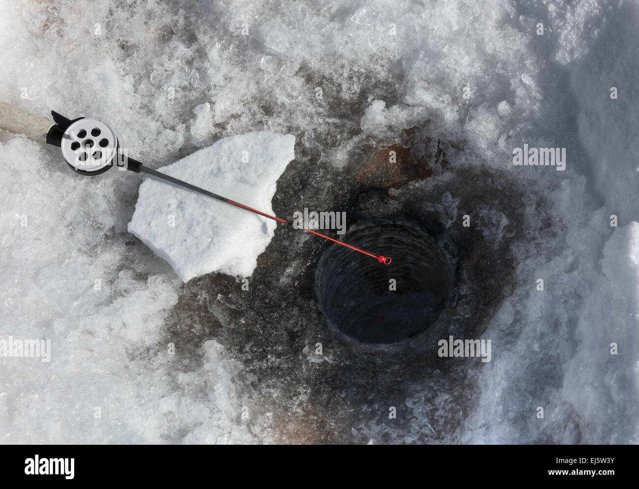 Canne à pêche pour la pêche sur glace sur le fond des trous Banque D'Images