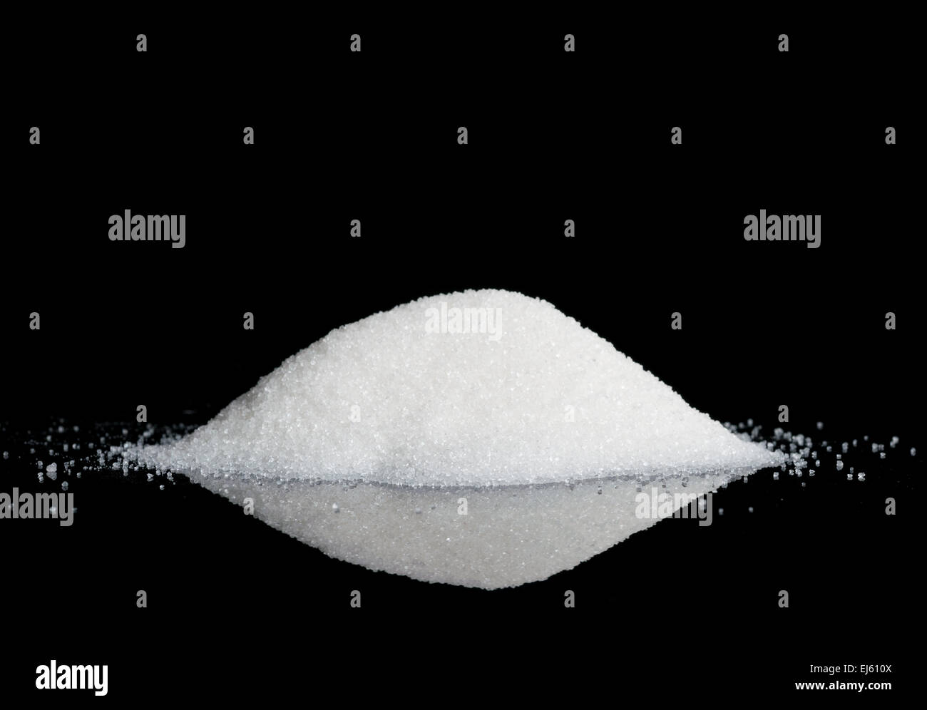 Sucre blanc granulé sur fond noir reflétant Banque D'Images
