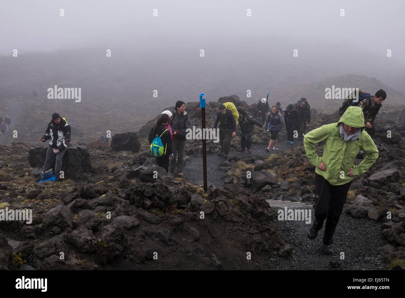 Les promeneurs sur les Tangariro crossing alpin à pied dans des conditions météorologiques extrêmes. La Nouvelle-Zélande. Banque D'Images