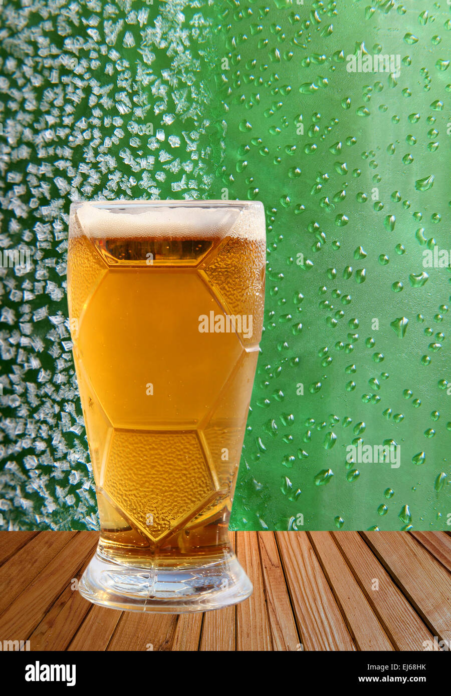 Verre à bière prise libre contre des cristaux de glace et les gouttes fond vert. Banque D'Images