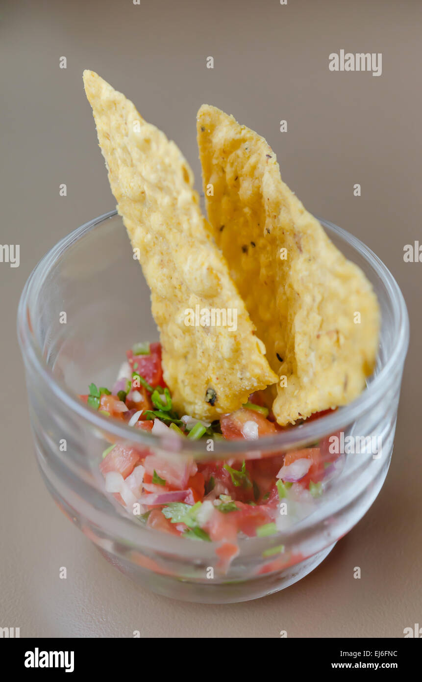 Croustilles avec trempette salsa dans verre à cocktail Banque D'Images