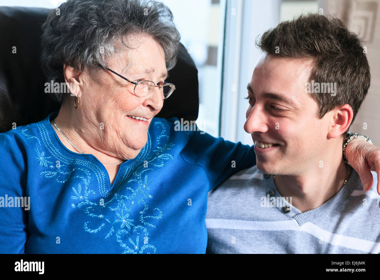Un petit-fils avec sa grand-mère dans sa chambre Banque D'Images
