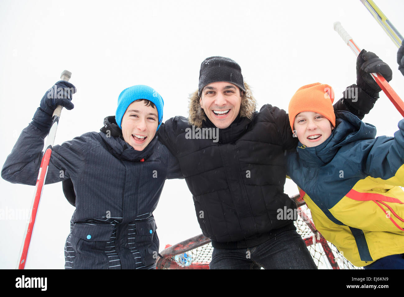 Une famille à jouer à la patinoire en hiver. Banque D'Images