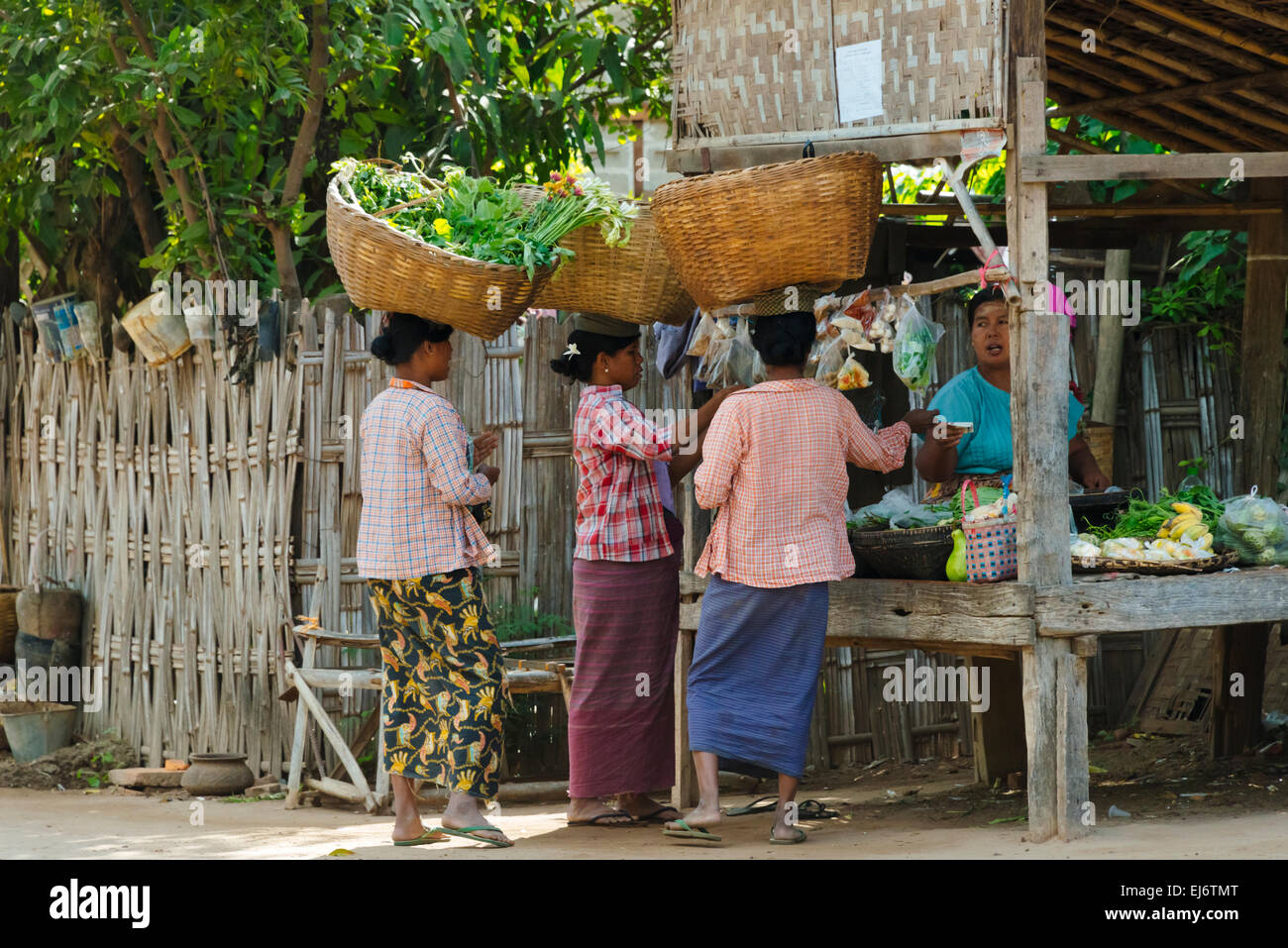 Les femmes portant des paniers sur la tête dans le village, Bagan, Mandalay, Myanmar Région Banque D'Images