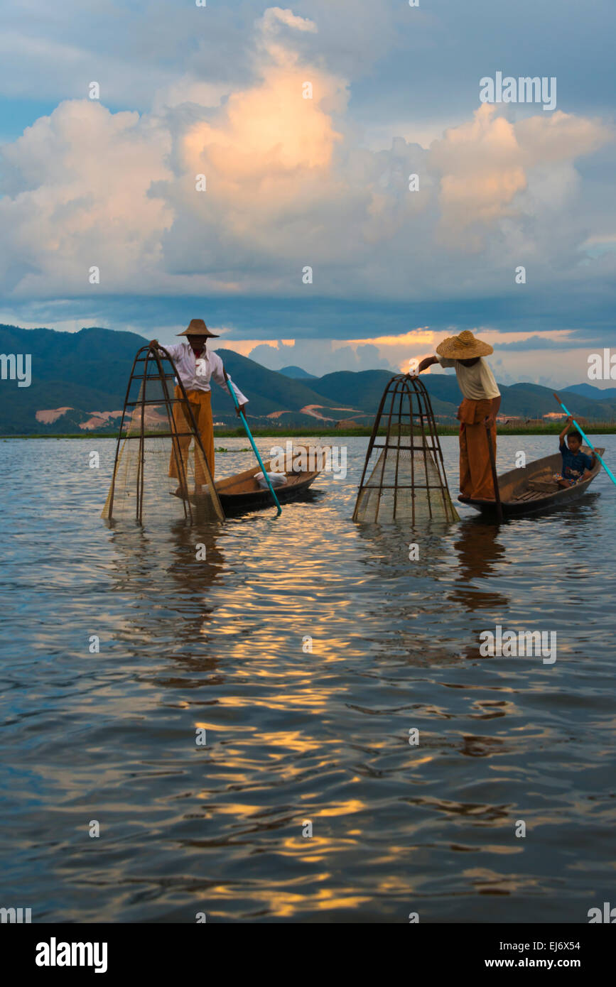 Barque de pêcheur ethnie Intha avec jambe au coucher du soleil sur le lac Inle, l'État de Shan, Myanmar Banque D'Images