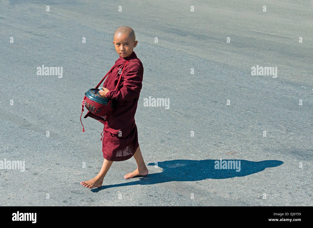 Petit moine holding alms wok, Yangon, Myanmar Banque D'Images