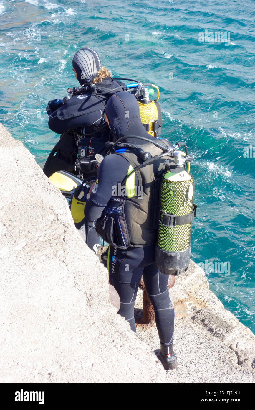 Deux plongeurs se préparent à aller plonger dans la mer à Punta de la aldea, Gran Canaria, Espagne Banque D'Images