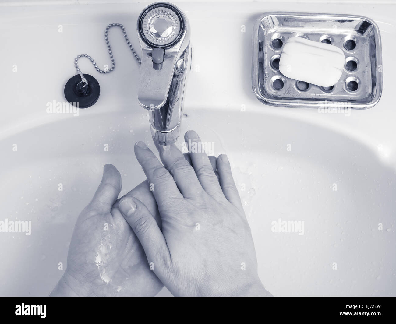 L'homme se lavent les mains sans le savon dans le lavabo au-dessus, teinté bleu image en noir et blanc Banque D'Images