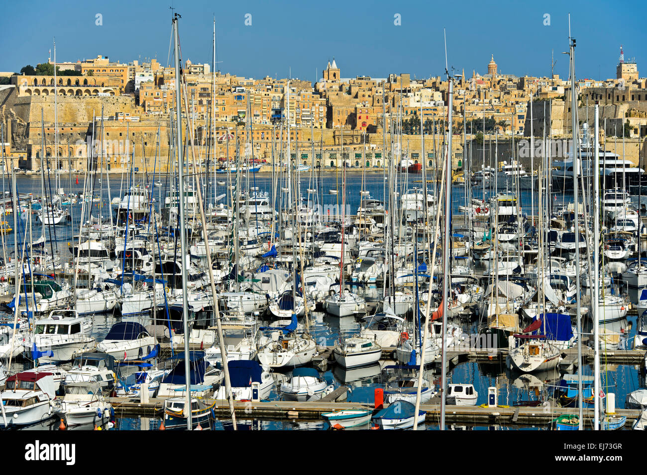 La voile des bateaux amarrés dans le grand port de plaisance de Vittoriosa contre le pittoresque arrière-plan de la Valette, Malte Banque D'Images