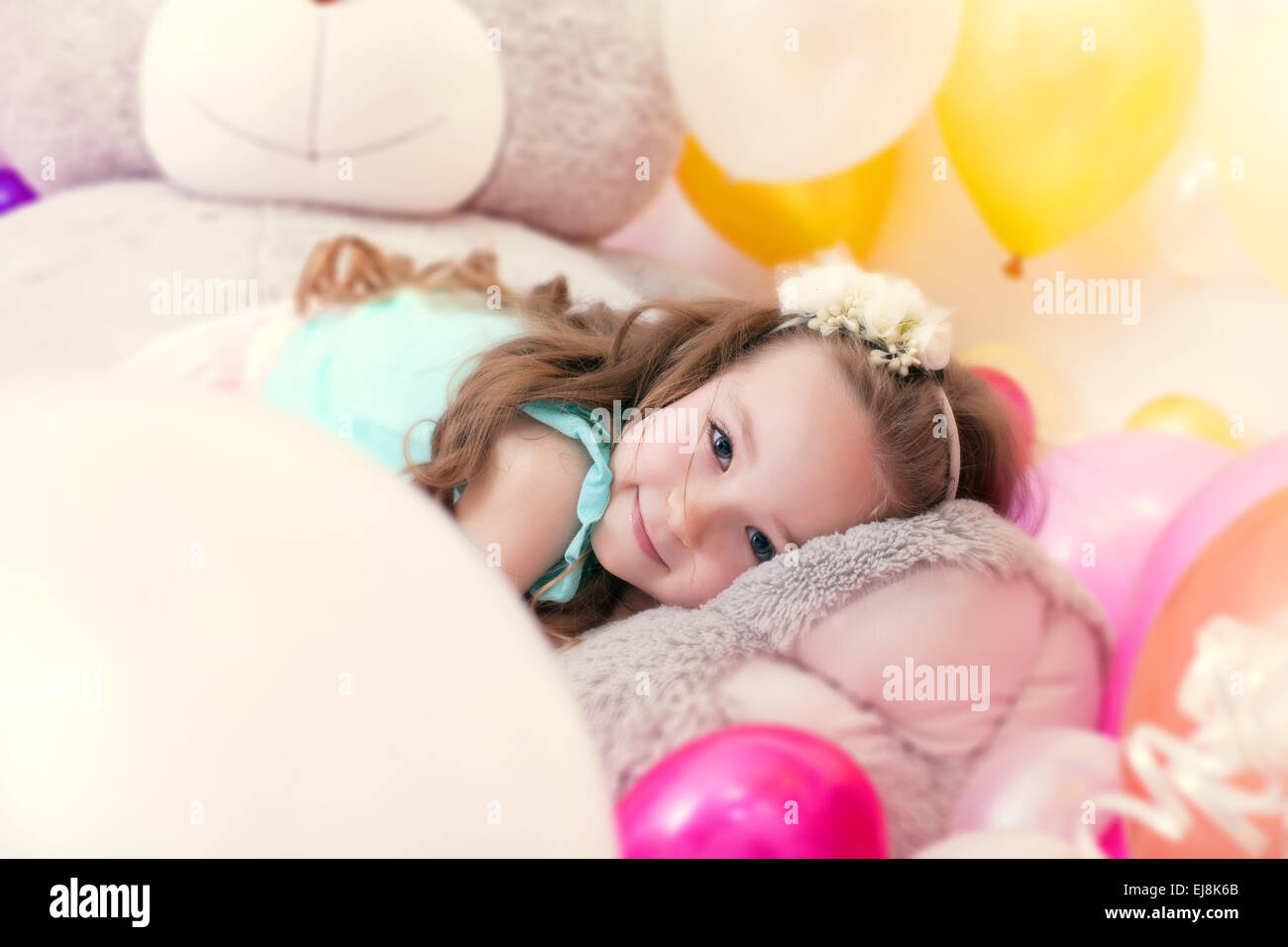 Adorable petite fille couchée sur l'ours en peluche Banque D'Images