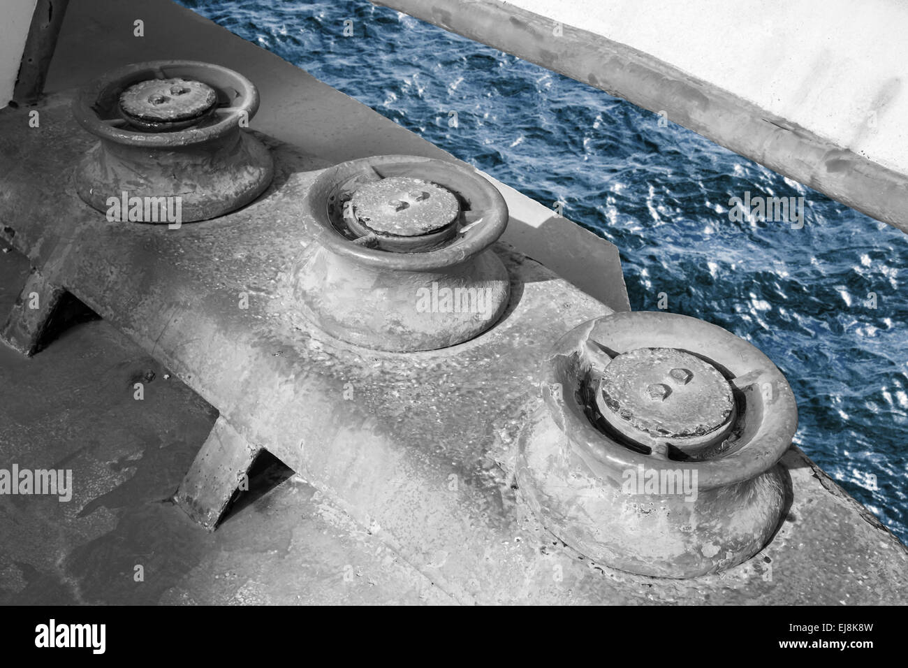 Vieux grungy rouleaux pour amarres, navire industriel fragment monochrome bleu avec de l'eau de mer Banque D'Images