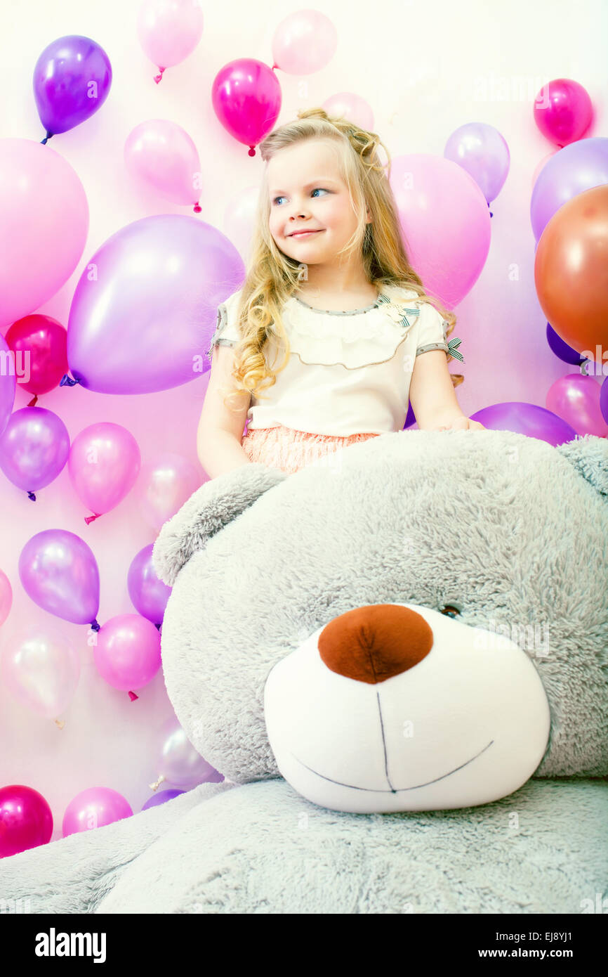 Smiling little girl posant avec un ours en peluche Banque D'Images