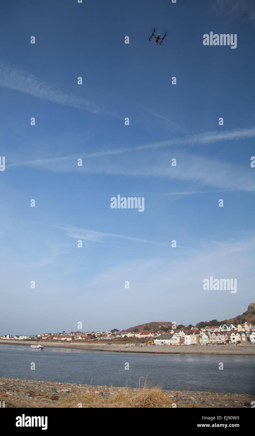 Une télécommande caméra drone plane sur la plage contre un ciel bleu profond à la mer plage de Conwy, au Pays de Galles Banque D'Images
