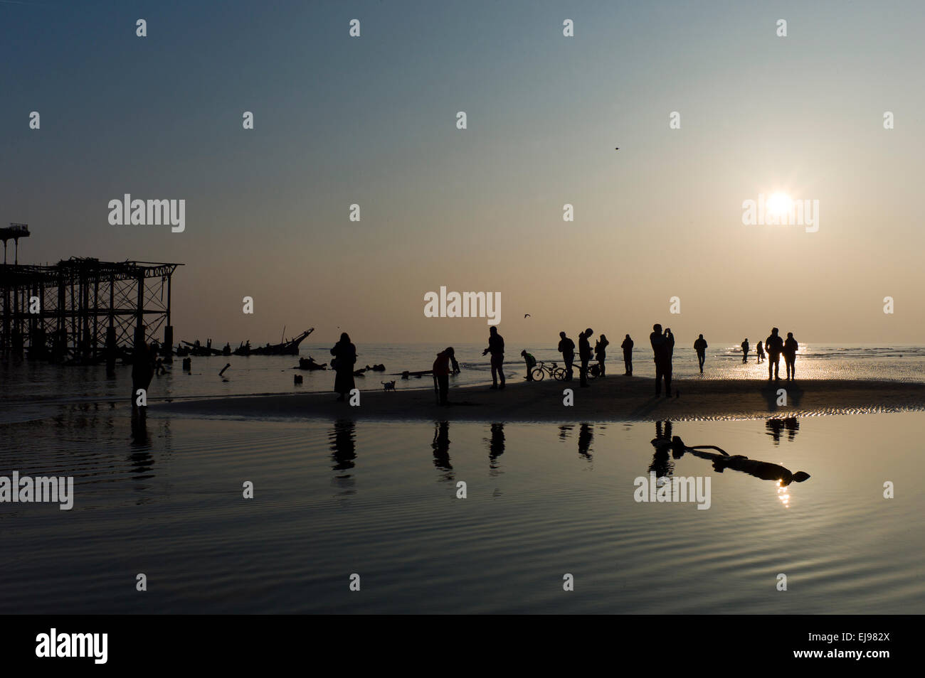 Les gens sur la plage, la marée la plus basse de l'année, de l'épave, Brighton West Pier sunset,, silhouette Banque D'Images