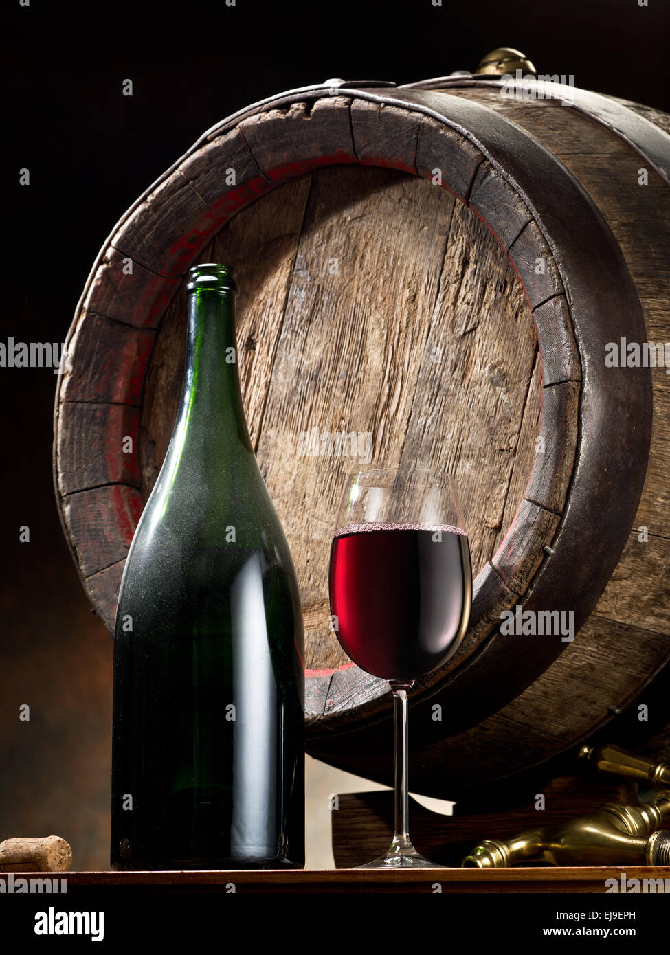 La nature morte avec verre de vin, la bouteille et le baril sur la table dans la cave. Banque D'Images