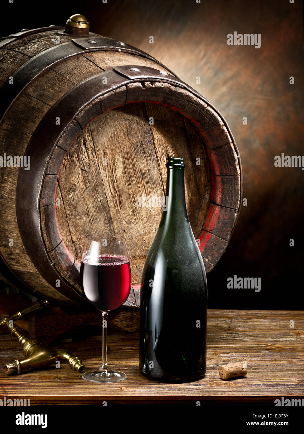 La nature morte avec verre de vin, la bouteille et le baril sur la table dans la cave. Banque D'Images