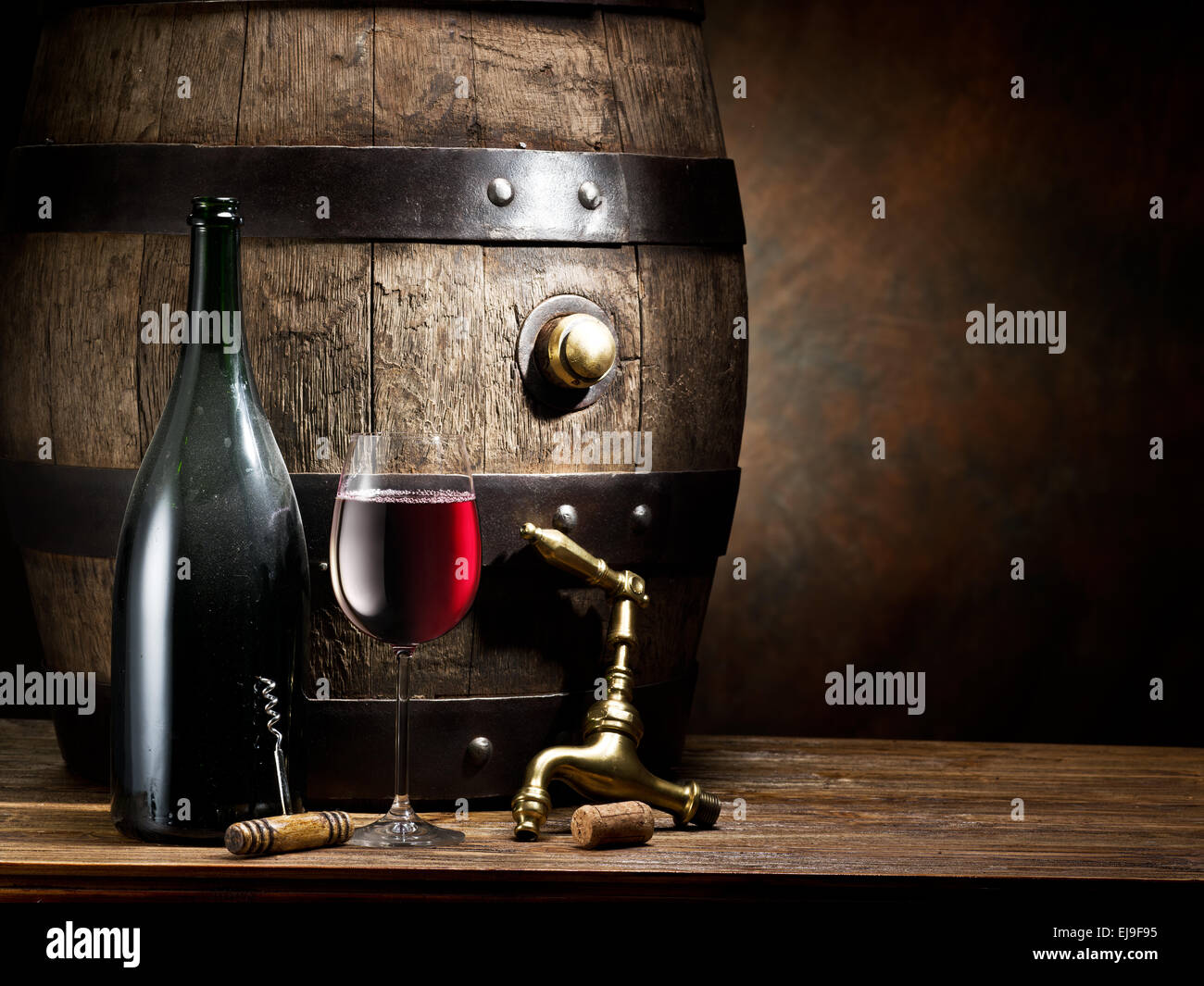 La nature morte avec verre de vin, la bouteille et le baril sur la table dans la cave. Banque D'Images