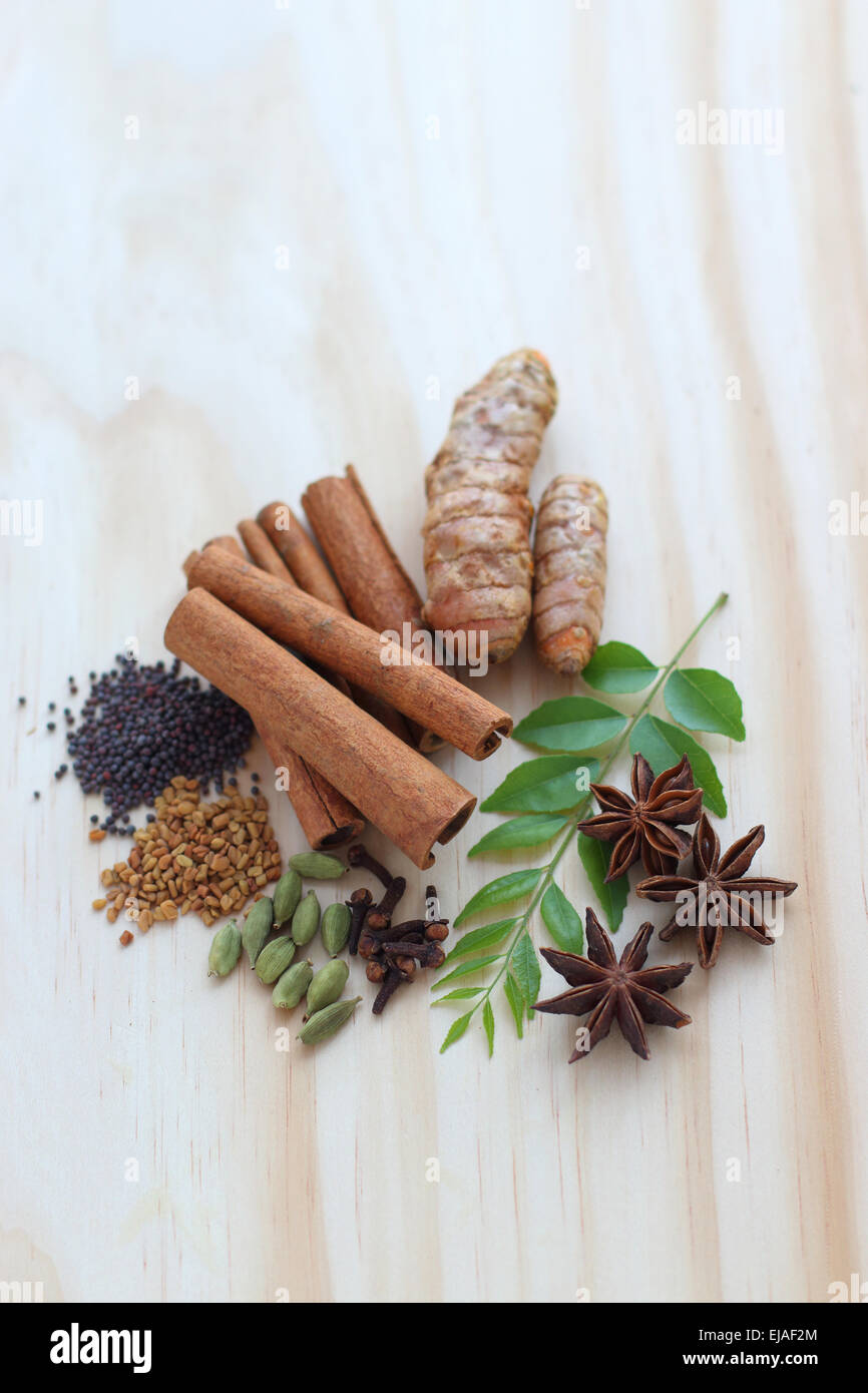 Un assortiment d'épices séchées y compris murraya koenigii sur une planche en bois Banque D'Images